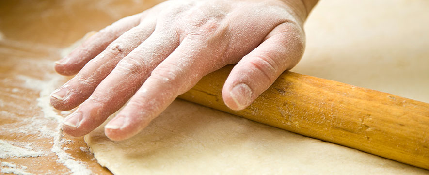 hand rolling out dough using rolling pin